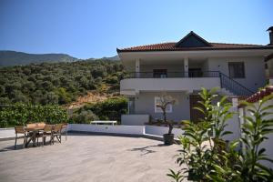 a house with a patio with a table and chairs at Olive Tree in Tirana