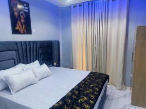 a bedroom with a large bed with a black and yellow blanket at Glossy Luxury Hotel in Akure