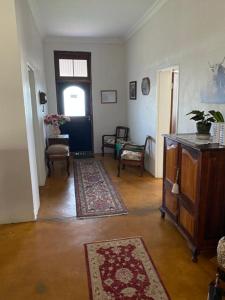 a living room with a door and a hallway with rugs at Kareepoort Guest Farm in Bloemfontein
