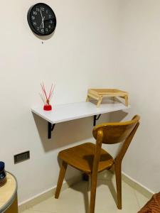 a desk with a chair and a clock on a wall at habitacion en sabaneta in Sabaneta