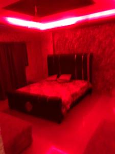 a red room with a bed with a red light at Sweet Moon in Lahore