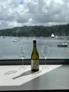 a bottle of wine and two wine glasses on a table at The Lookout in Tobermory