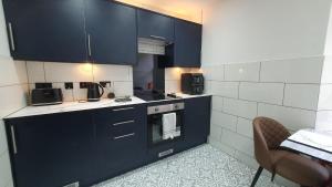 a kitchen with blue cabinets and a table and a chair at The Lookout in Tobermory +9 photos