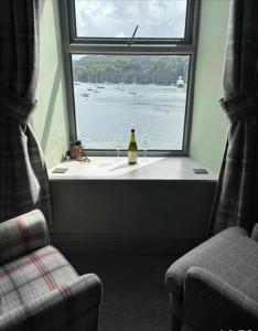 a window with a bottle of wine and two glasses at The Lookout in Tobermory