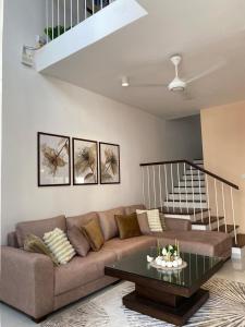 una sala de estar con un sofá y una mesa en Santorini Meraki Villas, en Negombo