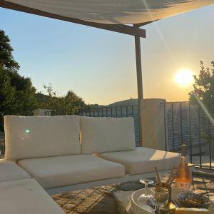Un sofá blanco y una mesa en un patio. en Maison authentique 4 à 10 personnes, en Ersa