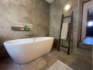 y baño con bañera blanca y toallero. en Maison authentique 4 à 10 personnes, en Ersa