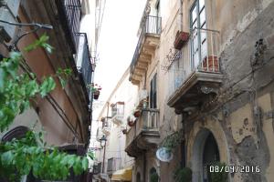 an alley with buildings and balconies in a city at Regina Reginella in Syracuse