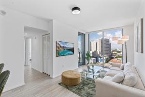 マイアミにあるDowntown Miami Luxe Studio Suiteの白いソファと大きな窓のあるリビングルーム +21枚の写真