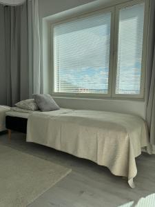 a bedroom with a bed and a large window at Pramea Apartments Matkatupa in Kuopio
