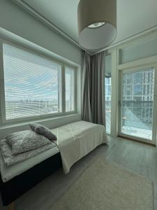 a bedroom with a bed and a large window at Pramea Apartments Matkatupa in Kuopio