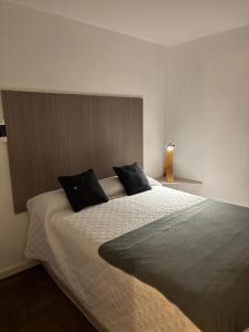 a bedroom with a large bed with two black pillows at Depto 23 en Barrio Villa Belgrano excelente ubicación in Cordoba