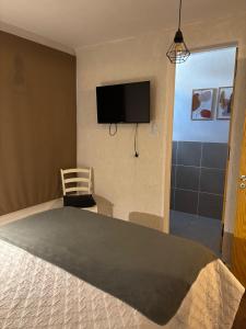 a bedroom with a bed and a flat screen tv at Depto 23 en Barrio Villa Belgrano excelente ubicación in Cordoba