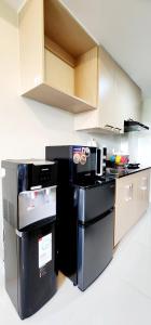 eine Küche mit schwarzen Geräten und Geräten aus Edelstahl in der Unterkunft 517 New Brenthill Premium Condo Near SMBaguio in Baguio City