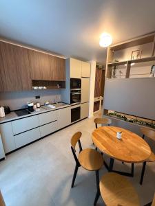a large kitchen with a wooden table and chairs at Zyra Blue Heart Pool & Spa in Năvodari