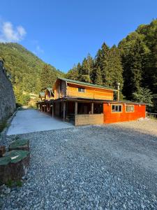 a house on a gravel road next to a mountain at Ayder Villa Gencal King in Ayder Yaylasi