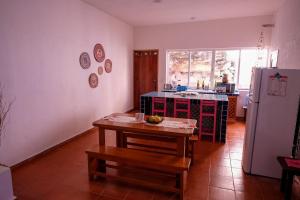 a kitchen with a table and a refrigerator at House by the beach Casa Murmullos in Isla Mujeres