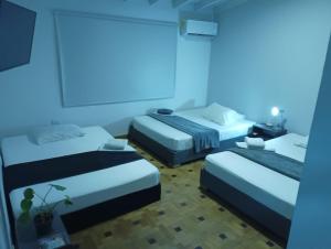 two beds in a room with blue lights at La Carpita Hotel in El Poblado
