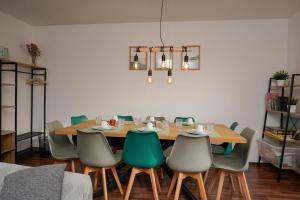 a dining room with a wooden table and green chairs at Große, gemütliche 4-Zimmer-Ferienwohnung mit guter Verkehrsanbindung im Süden von Heidelberg in Heidelberg