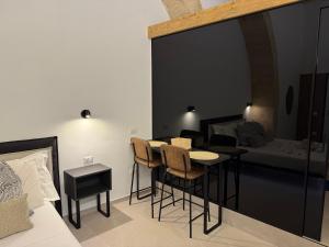 a room with a bed and a table and chairs at B&B Vitale in Gravina in Puglia