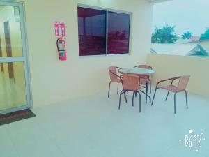 un patio con tavolo, sedie e una finestra di Hostal Montecarlos a Salinas