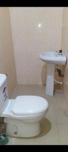 a bathroom with a white toilet and a sink at GA guest House in Ibadan +7 photos