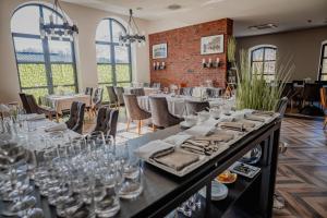 a dining room with tables and chairs and windows at Hotel Malbork - Centrum Konferencyjne in Malbork