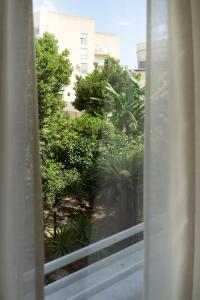 a view of a garden from a window at Cálida apartments in Cefalù