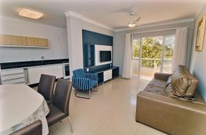 a kitchen and living room with a couch and a table at Baía dos Golfinhos in Bombinhas