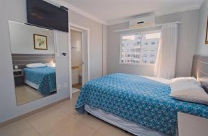 a small bedroom with a bed and a window at Baía dos Golfinhos in Bombinhas