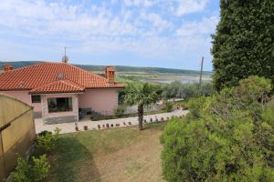 una casa blanca con una palmera en un patio en Mejak & Bordon, en Sečovlje