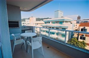 a balcony with a table and chairs and a view of a building at Baía dos Golfinhos in Bombinhas