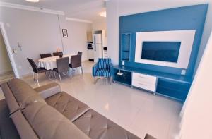 a living room with a couch and a dining room at Baía dos Golfinhos in Bombinhas
