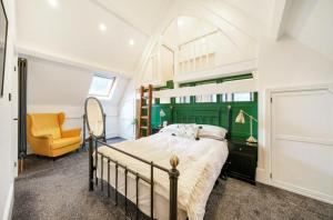 a bedroom with a bed and a yellow chair at School Cottage conversion in Grove Park