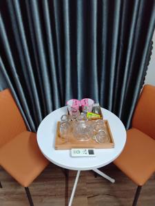 a white table with two chairs and a tray with drinks on it at Hotel LOAN ÐÀI in Bùi Tiếng