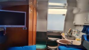 a small room with a tv and a sink and a bathroom at Long term Golf del Sur in San Miguel de Abona