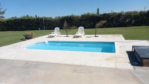 a swimming pool with two lawn chairs at Cumbres del Sol in Albardón +6 photos