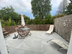 Un patio con una mesa y sillas y una sombrilla. en Maison d Angele 4 chambres, en Chambray-lès-Tours