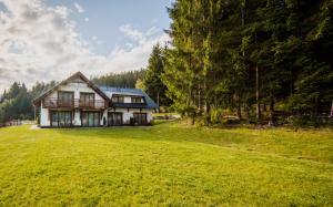 a house in a field with a large yard at Apartmány Bílá 188 in Bílá