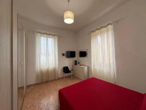 a bedroom with a red bed and a desk and window at House 130 Francavilla B&B in Francavilla al Mare