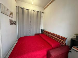 a red bed in a small room with a window at House 130 Francavilla B&B in Francavilla al Mare