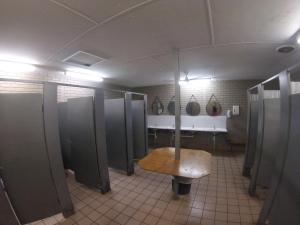 a bathroom with stalls and a bench in it at Cable Beach Backpackers in Broome