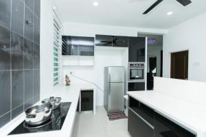 a kitchen with stainless steel appliances and black and white at Tanjung Bungah Villa 20 pax Mahjong Snooker and More Close to Beach in Tanjung Bungah