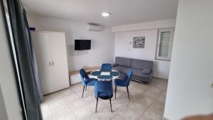 Una sala de estar con una mesa y sillas y un sofá. en Apartments Ostrea - Mimoza, en Novalja