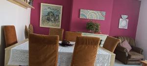 a dining room with a table and a purple wall at As Chaves do Cantinho da Paz in Santarém