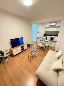 a living room with a couch and a tv and a table at Departamento Moderno y céntrico in Salta
