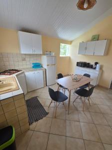 a kitchen with a table and chairs in a room at Chez Josie et Julien in Sainte-Rose