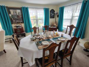 a dining room with a table and chairs with blue curtains at Digby Bed and Breakfast in Digby