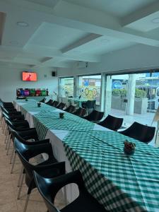 a row of tables and chairs in a room at Hotel De La Prada in Maicao