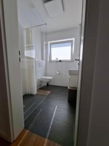 une salle de bain avec toilettes, lavabo et fenêtre dans l'établissement Charmante Ferienwohnung in Tecklenburg, à Tecklembourg